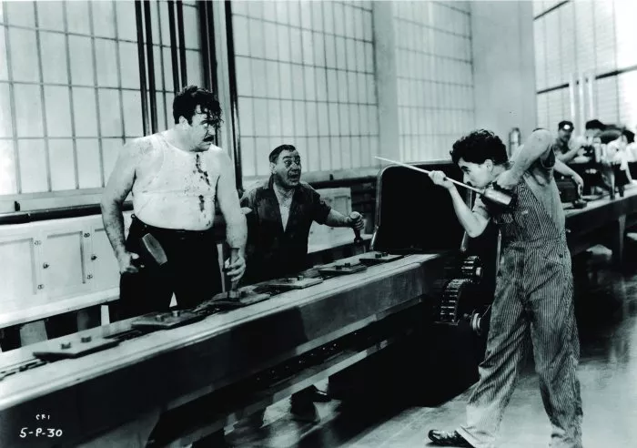 Charles Chaplin (A Factory Worker), Heinie Conklin (Assembly Line Worker Next to Big Bill), Tiny Sandford (Big Bill) zdroj: imdb.com